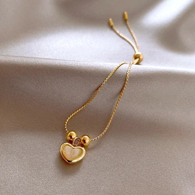 Bracelet doré cœur aux reflets d'opale pêche