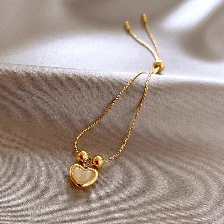 Bracelet doré cœur aux reflets d'opale pêche