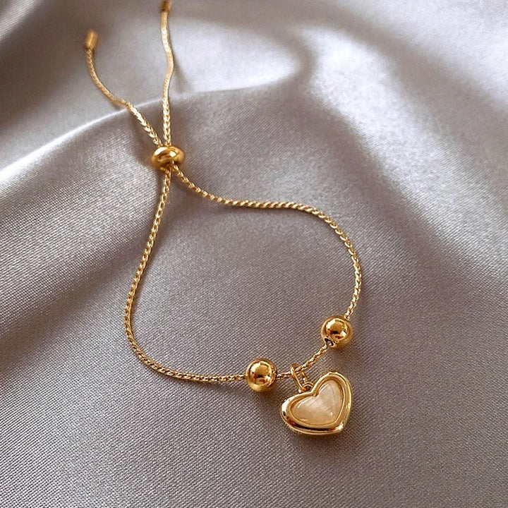 Bracelet doré cœur aux reflets d'opale pêche