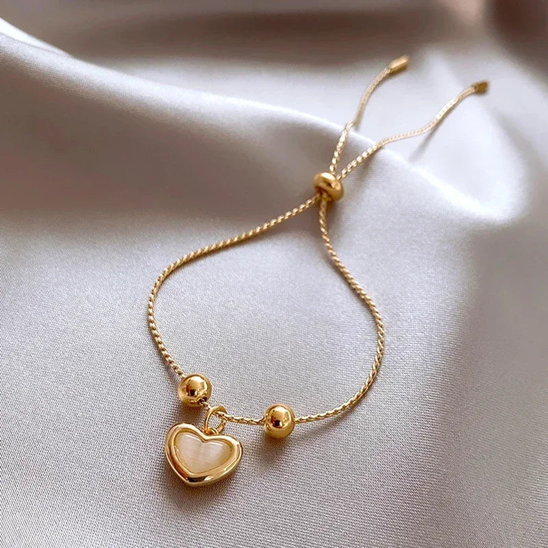 Bracelet doré cœur aux reflets d'opale pêche