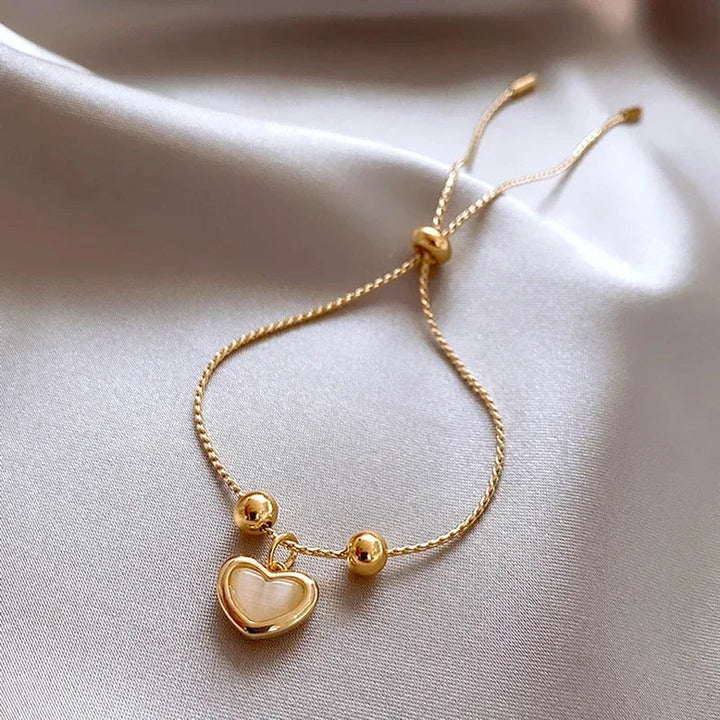 Bracelet doré cœur aux reflets d'opale pêche
